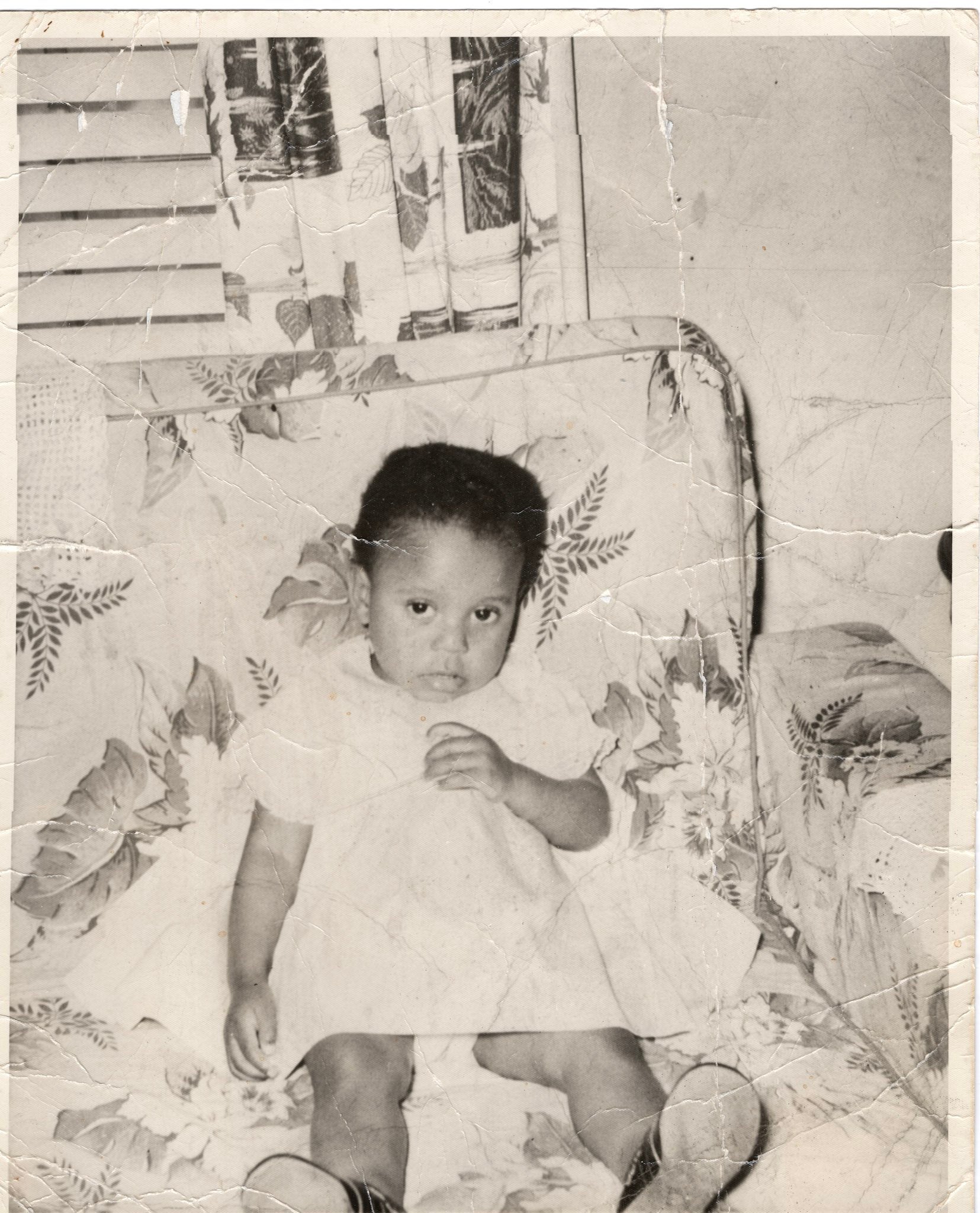 a photo of a young child seen sitting on a chair inside of a residence.