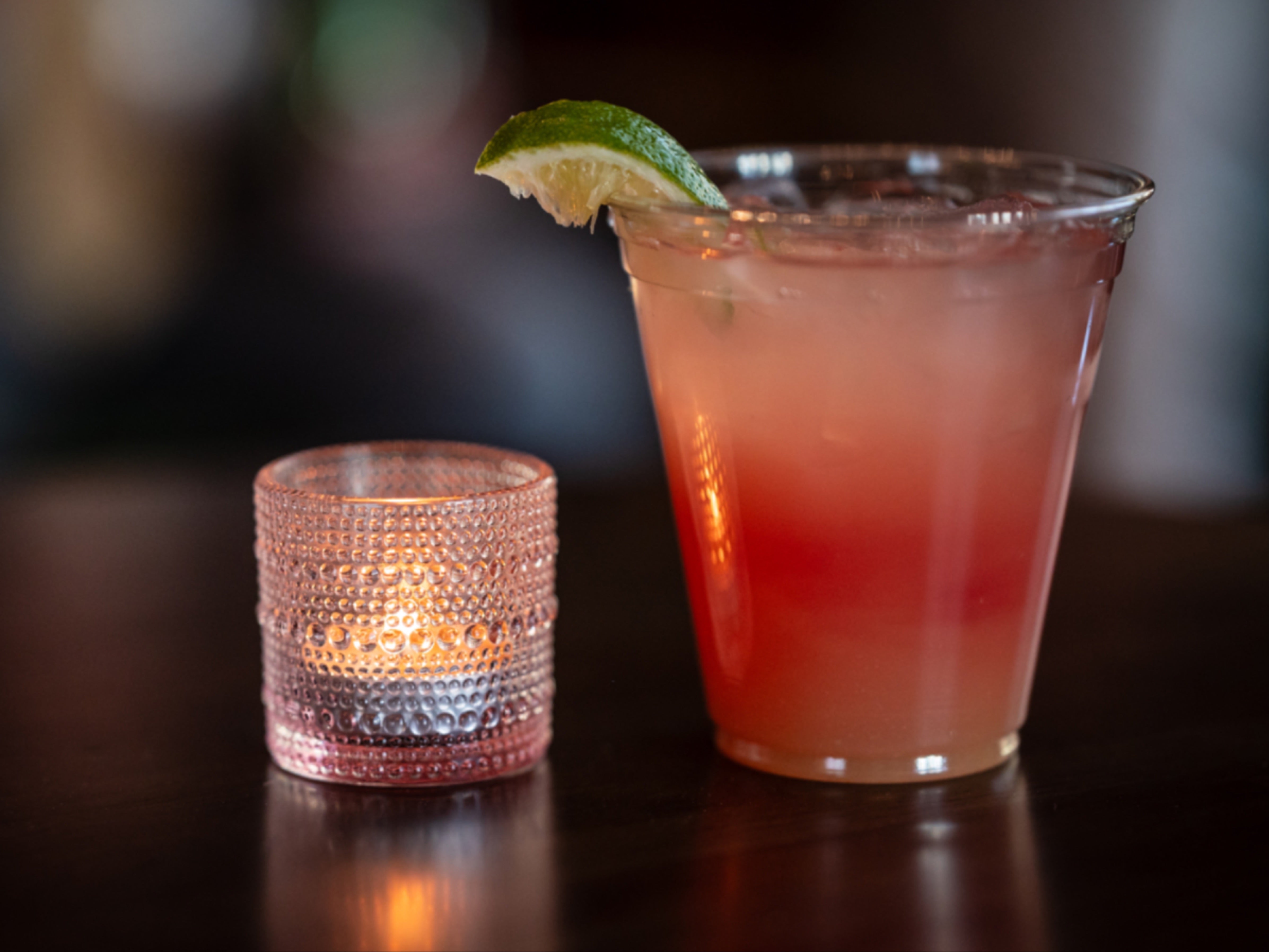 A photo of a cocktail and a tea light candle
