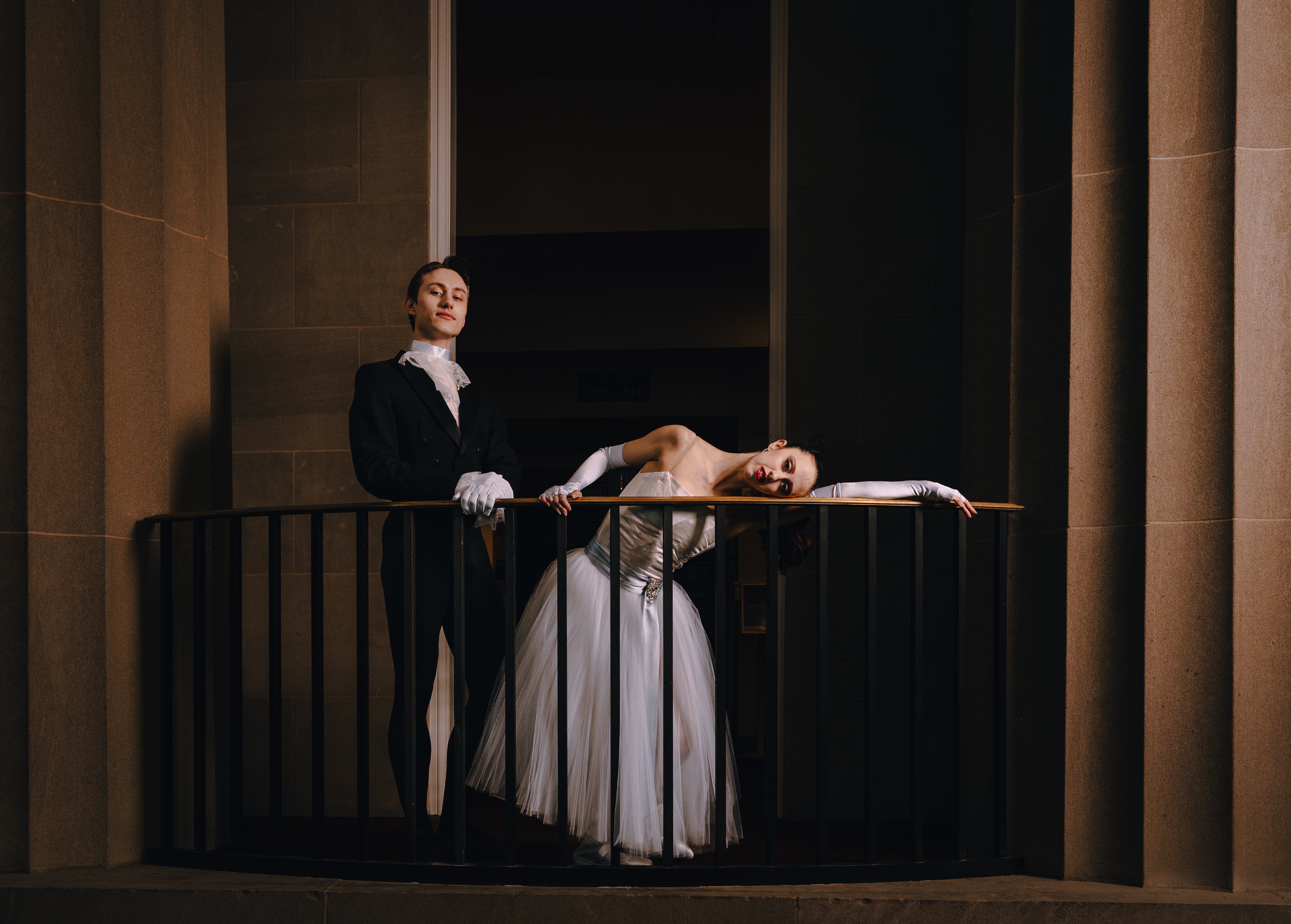 Two Carolina ballet performers shown on a balcony they are wearing formal attire