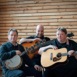 Photo of the three Kruger Brothers who are each holding a stringed instrument. 