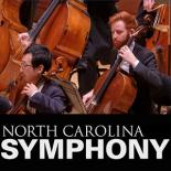 Two people playing cellos among the orchestra.
