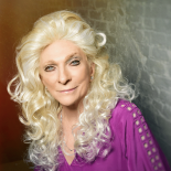 a photo of Judy Collins she is wearing a pink blouse