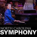 Photo of Michael Cavanaugh sitting at and playing a piano