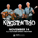 Photo of The Kingston Trio wearing a blue strip shirt and playing the guitar
