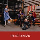 Photo of three child dancers and one male dancer in costume in set shop