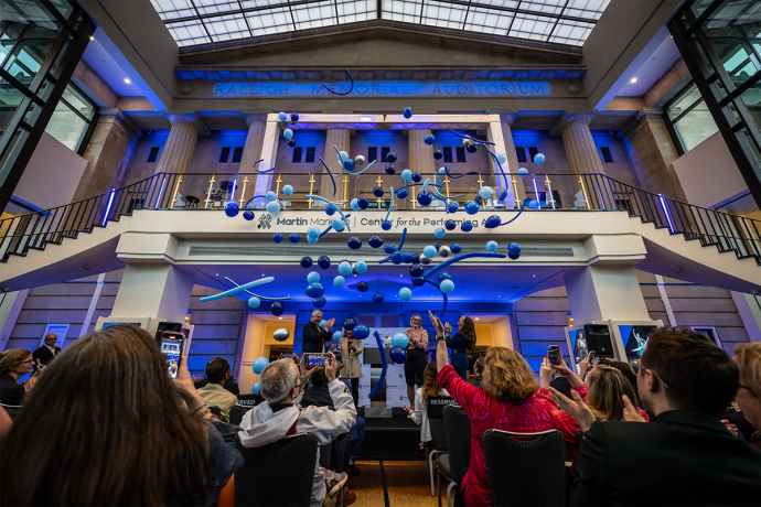 A photo of the raleigh memorial auditorium lobby showing the new sign with ballots falling