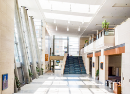Photo of the main lobby of the raleigh convention center. The lobby is empty and stairs are in the background