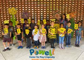 Powell Elementary students who named the new queen bee at the Martin Marietta Center pose with a sign that reads Queen Elizabuzz