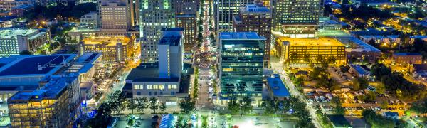 A night time aerial photo of Downtown Raleigh facing the NC State Capitol