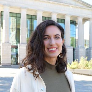 a photo of Melanie Margarum she has shoulder length brown hair and is wearing a green blouse and white jacket