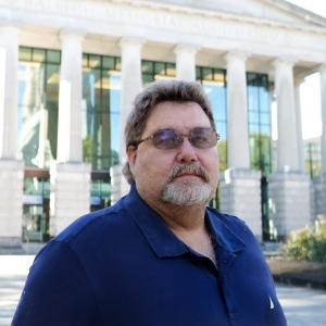 a photo of Russell Denton he is wearing glasses and has on a dark navy polo