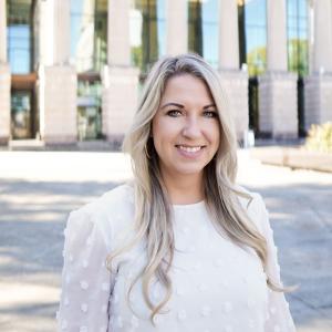 a photo of SARAH MCALISTER she has long blonde hair and is wearing a white blouse