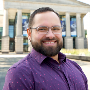 a photo of Andrew armas he is wearing glasses and has on a purple button down shirt