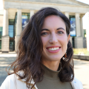 a photo of Melanie Margarum she has shoulder length brown hair and is wearing a green blouse and white jacket