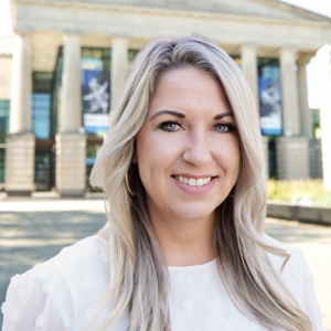 a photo of SARAH MCALISTER she has long blonde hair and is wearing a white blouse